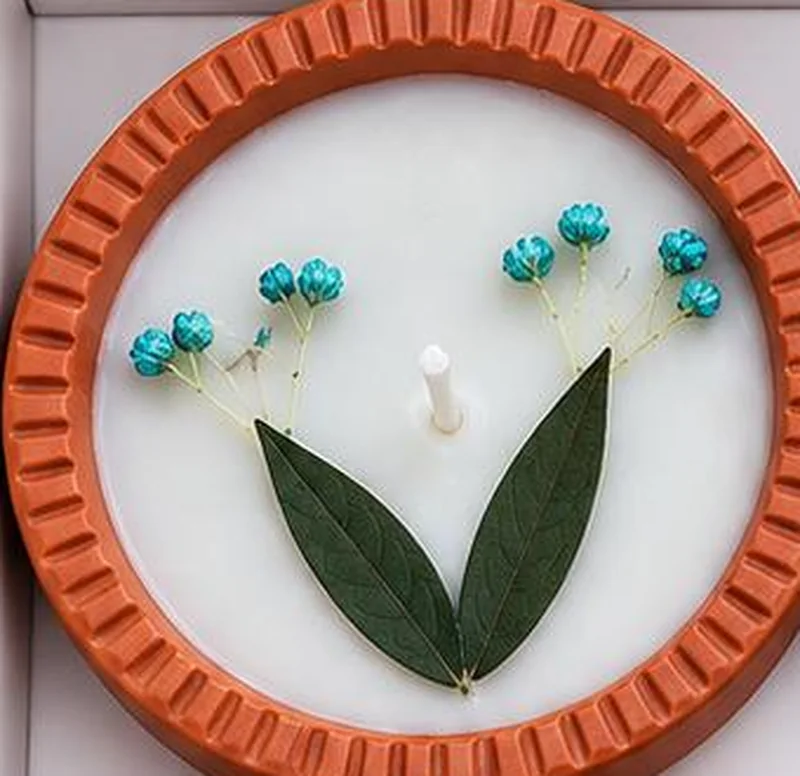 Smooth white wax filling a diya to its rim, with a small white wick at the centre.