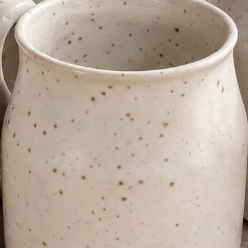 Close view of the cream glaze with scattered fine brown speckles.