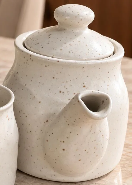 The kettle from the front, showing its short upturned spout, rounded body and fitted domed lid.